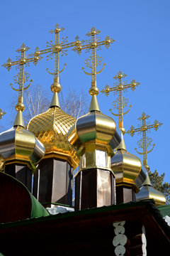 Gold-plated domes with crosses of wooden Russian Orthodox Christian Church of St. Nicholas in Ganina Yama Monastery on early Spring, Ekaterinburg, Russia.