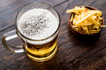 Glass of Beer with potato chips.