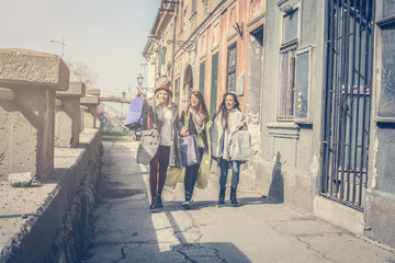 Three best friends walking on the street .