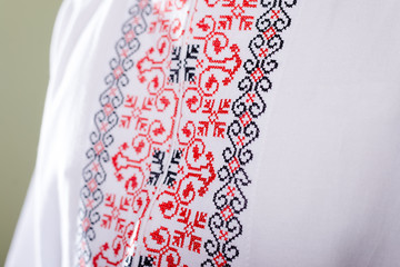 Closeup on man in Ukrainian handmade embroidered shirt on studio background