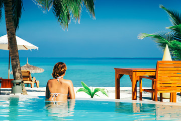 Fototapeta na wymiar Woman in swimming pool at tropical island