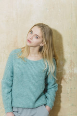 Pretty young girl with blond hair in fashionable sweater