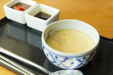 steamed egg in bowl on black tray