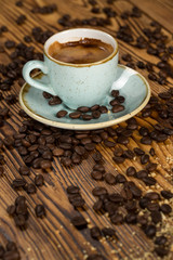 Made with love. High angle shot of a cup of coffee on a table full of roasted coffee beans.
