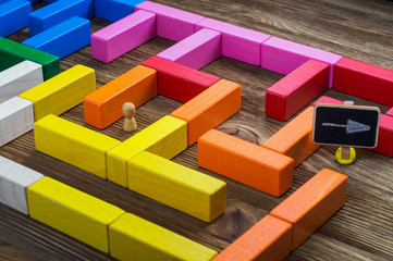 Man in the labyrinth, the search for the exit. Labyrinth of colorful wooden blocks, tetris. The man...