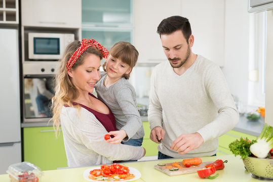 Young family preparing lunch from fresh veggies