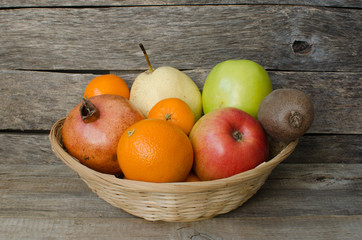 Fruits in basket on wooden background