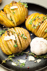 Baked potatoes with steam on a cast-iron frying pan close-up.