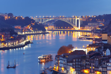Obraz premium Picturesque aerial view of Old town of Porto, Ribeira and bridge with mirror reflections in the Douro River during evening blue hour, Portugal