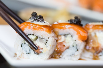 Sushi roll and black chopsticks