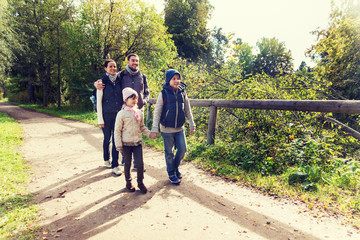 happy family with backpacks hiking in woods