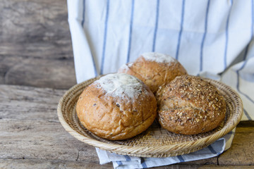 Whole wheat bread set in bamboo basket on wooden table top background