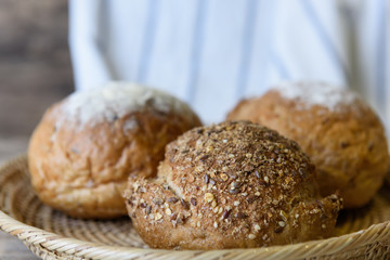 Whole wheat bread set in bamboo basket on wooden table top background