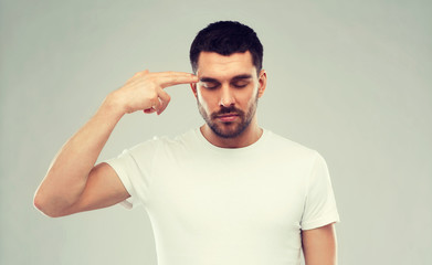 man making finger gun gesture over gray background