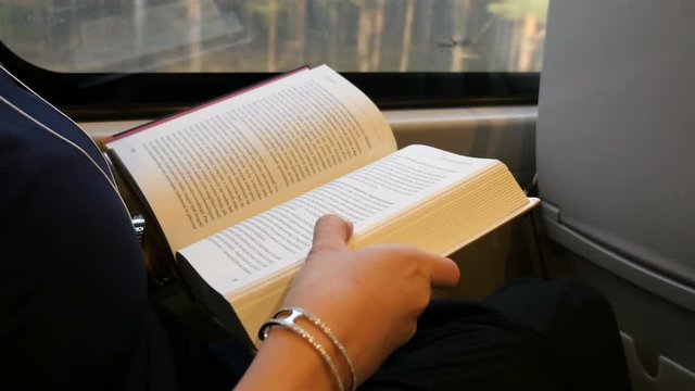 High quality video of woman reading a book in a train in 4K