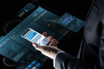 close up of businessman with charts on smartphone