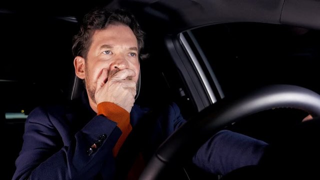 Sad man driving at night car getting furious