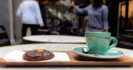 Cup of coffee and a cookie outdoors.