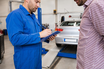 auto mechanic with clipboard and man at car shop