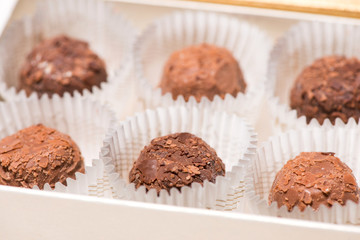 A lot of variety chocolates in box on white wooden background