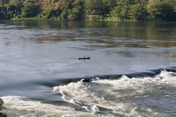View on Victoria Nile River rapids with fishers in boat. Jinja, Uganda, Eastern Africa. 
