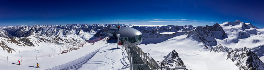 Panorama Bergstation von Gondelbahn Hinterer Brunnenkogel auf 3440 Meter im Skigebiet Pitztaler Gletscher bei wolkenlosem, strahlendblauen Himmel - obrazy, fototapety, plakaty
