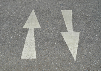 White arrow sign on asphalt road
