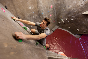 young man exercising at indoor climbing gym