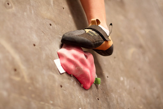 foot of woman on indoor climbing gym wall hold