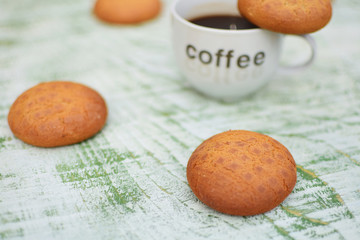 biscuits and cup of coffee on wooden background 