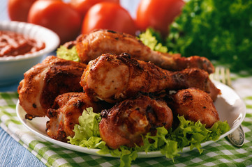 Baked chicken drumsticks with tomato dip.