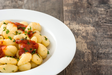 Gnocchi with tomato sauce on wooden background
