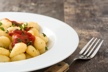 Gnocchi with tomato sauce on wooden background
