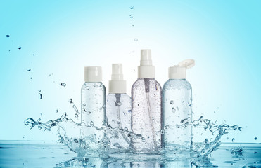 bottles of beauty products in a water splash isolated on blue background
