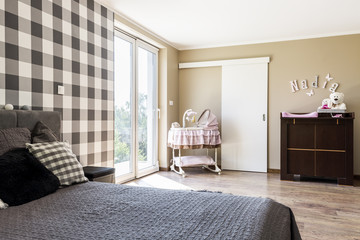 Beige bedroom with a newborn's corner