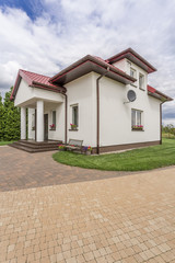 Fototapeta na wymiar Porches villa with cobblestone driveway idea