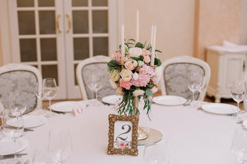 Wedding table decoration with the white and pink roses, carnations and candles