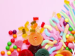 Abwaschbare Fototapete Bunte Bonbons und Fruchtgeleebonbons auf rosa Hintergrund © Olga Kriger