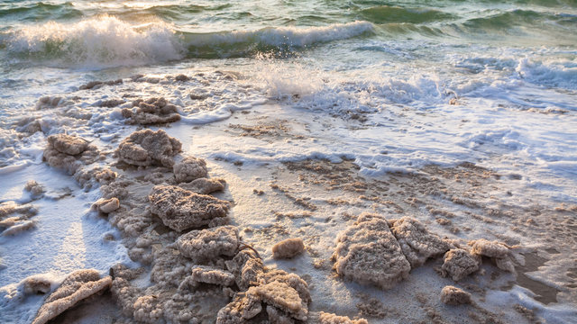 crystalline salt on shore of Dead Sea on sunset