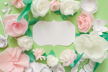 Vintage frame with color paper flower on green background.