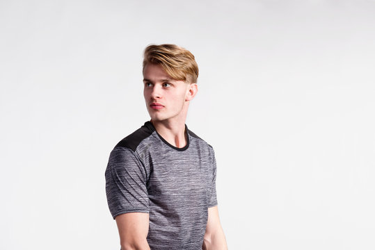 Young handsome hipster man in gray t-shirt, studio shot.