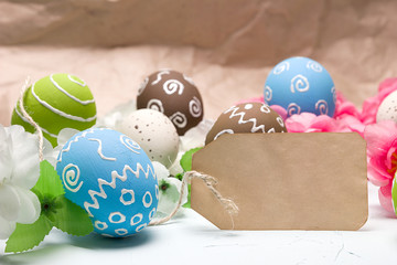Painted easter eggs and branches of spring sakura closeup on a light blue background with space for congratulation