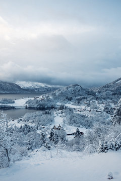 Snowscape, mountains, lake and stormy sky 