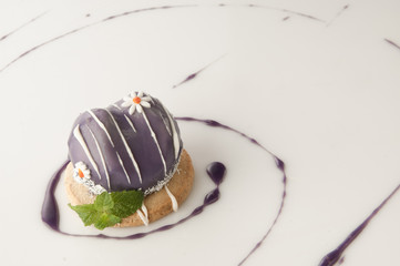 a piece of cake poured with sweet sauce over white background
