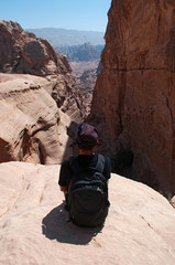 Giordania, 02/10/2013: un uomo di spalle seduto su una roccia sulla lunga salita, più di 800...