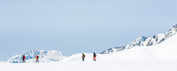 Skiers walking on snow covered mountain ranges - 143064782
