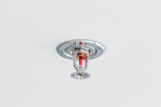 Close up image of fire sprinkler on white background. Fire sprinklers are part of an integrated water piping system designed for life and fire safety.