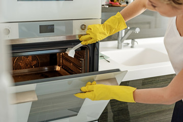 Careful housewife doing cleaning at kitchen