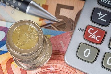 Finanzen, Euro Münzstapel, Kugelschreiber, Taschenrechner und Euroscheine, Draufsicht, Hintergrund