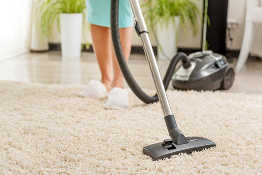 Woman cleaning room with vacuum cleaner